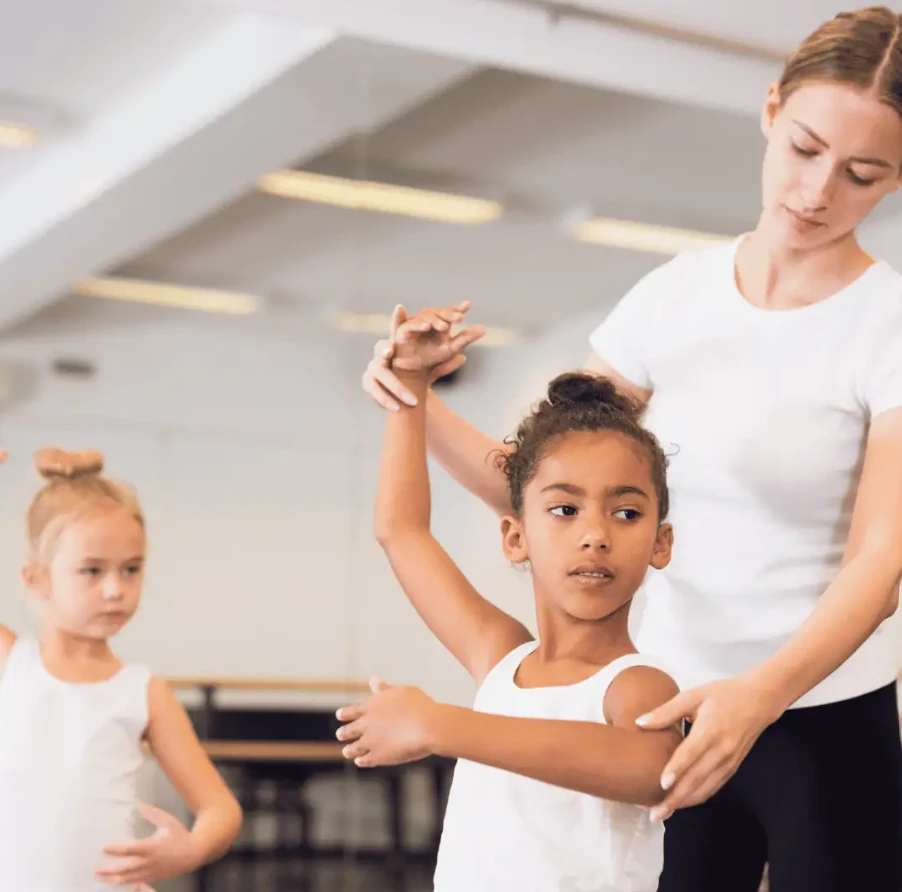Teacher guiding a young dancer